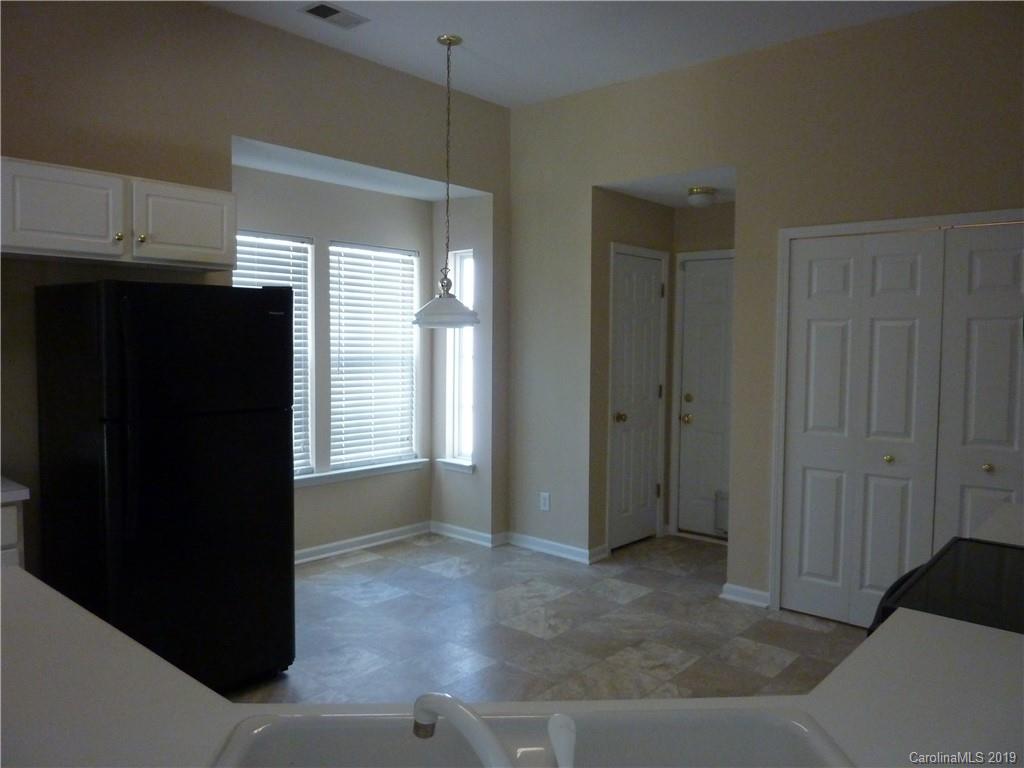 3607 Marbury Road Charlotte, NC 28269 - Photo 7 of 16 a view of an empty room with kitchen and wooden floor