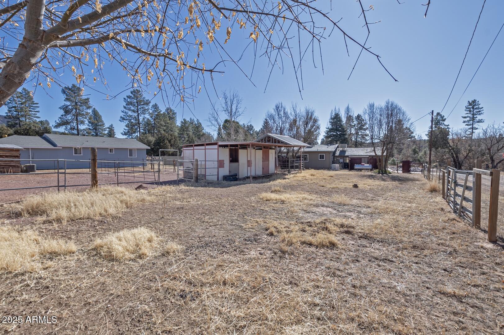 6066 S Road Pine, AZ 85544 - Photo 24 of 38 a view of a backyard with large trees and wooden fence