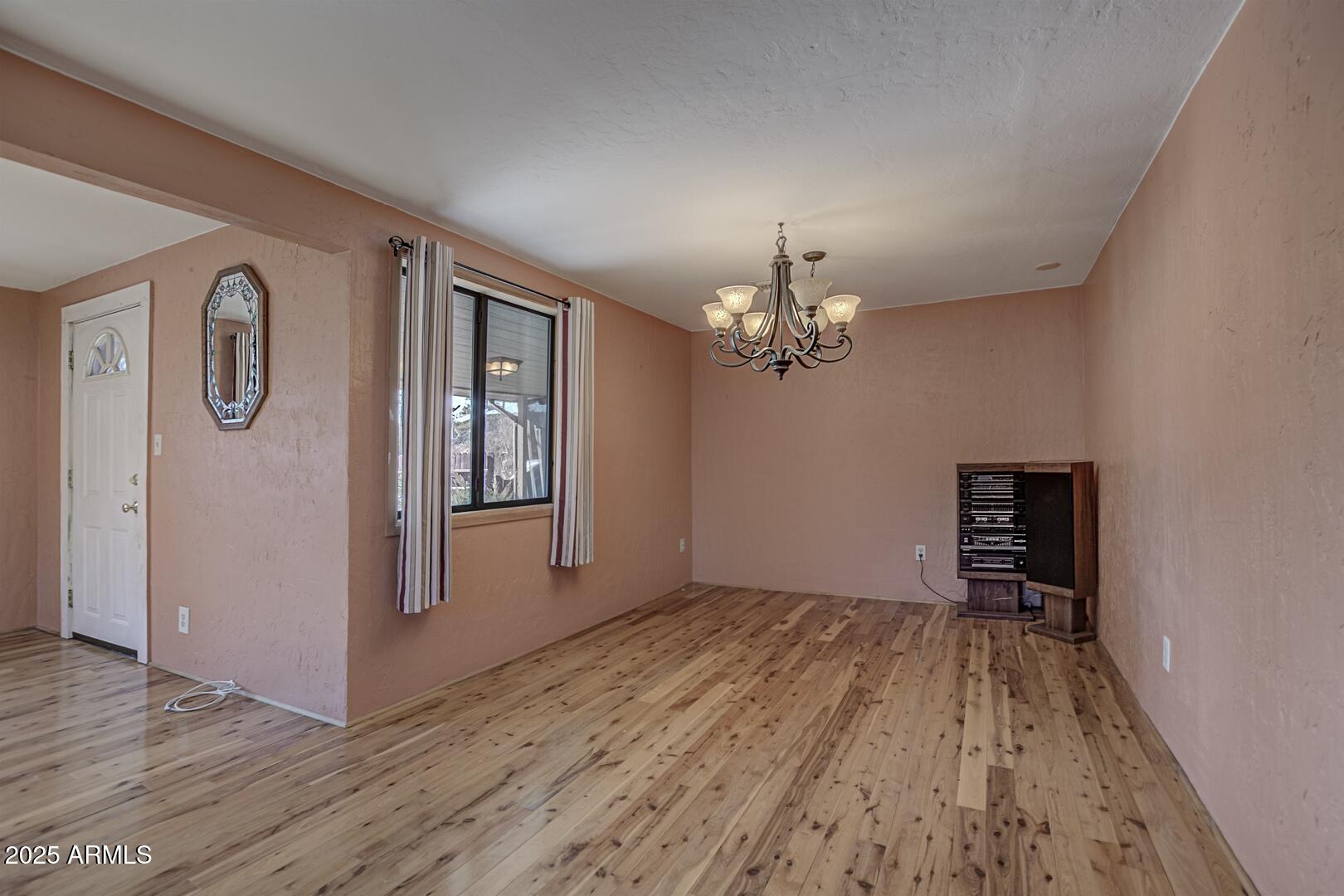 6066 S Road Pine, AZ 85544 - Photo 6 of 38 a view of a livingroom with a chandelier wooden floor and a kitchen