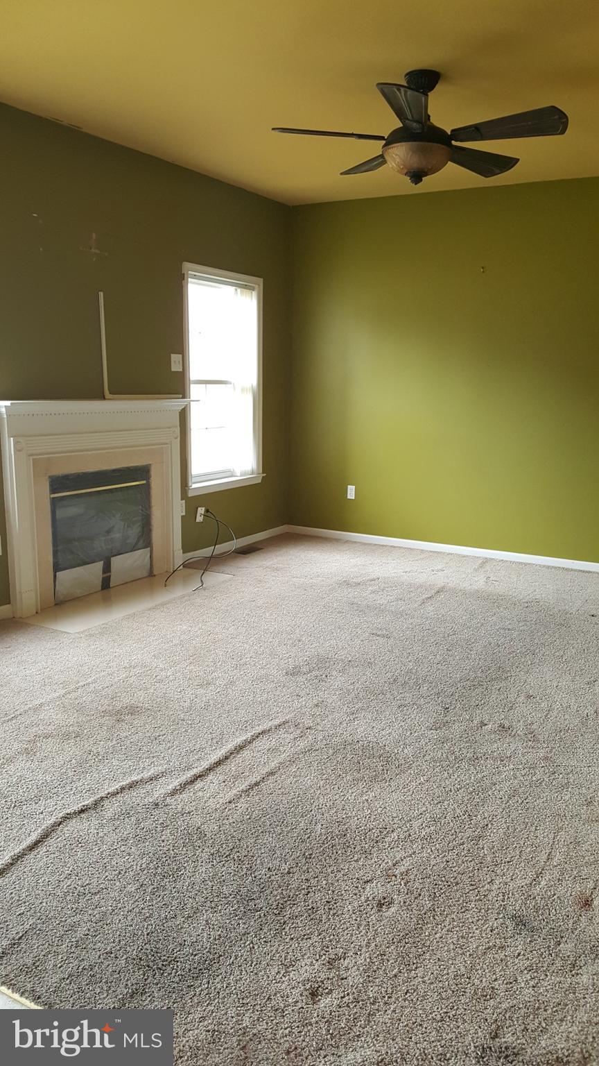 6990 Stuart Road King George, VA 22485 - Photo 5 of 15 a view of an empty room with a fireplace and a window