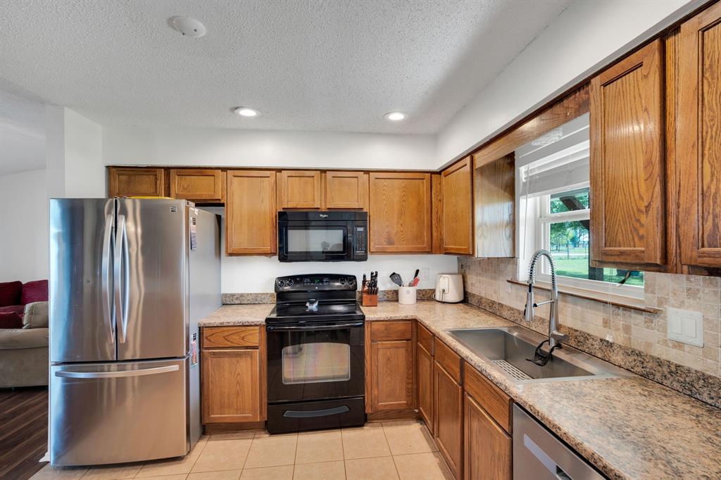 430 Carter Road Italy, TX 76651 - Photo 15 of 36 a kitchen with stainless steel appliances granite countertop a refrigerator stove and sink