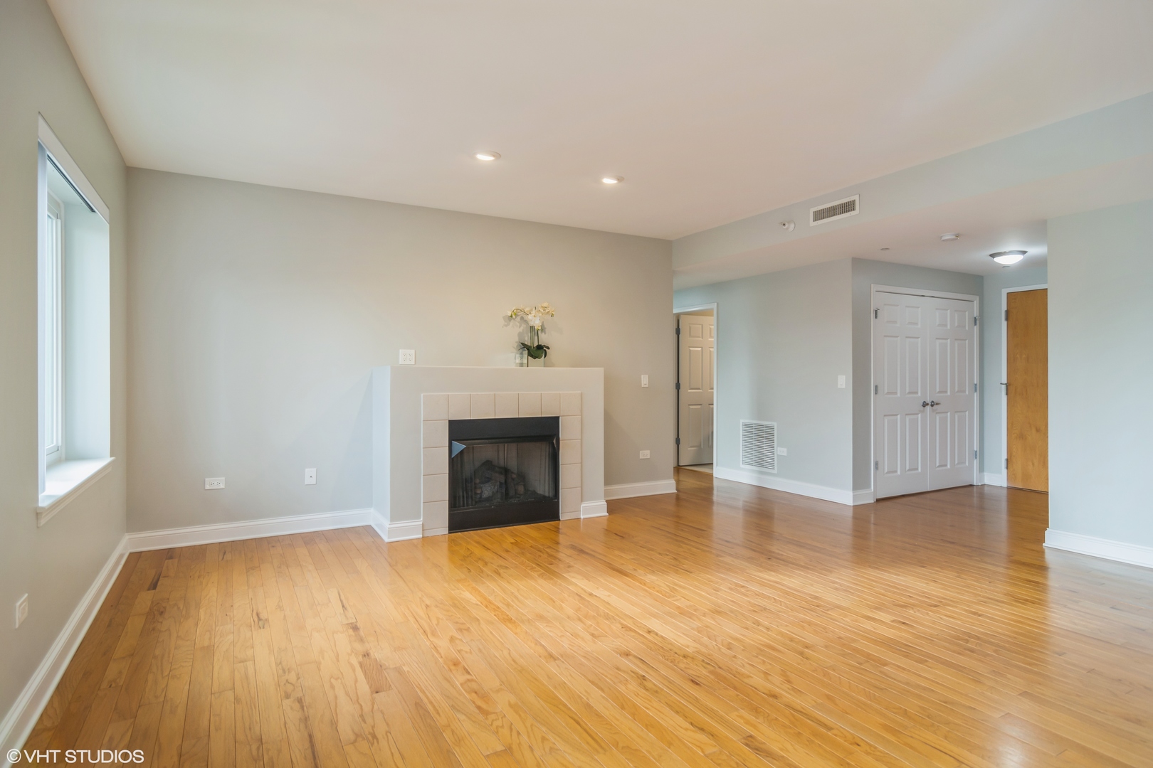 125 North Buffalo Grove Road, Unit 110 Buffalo Grove, IL 60089 - Photo 3 of 14 a view of empty room with wooden floor and fireplace