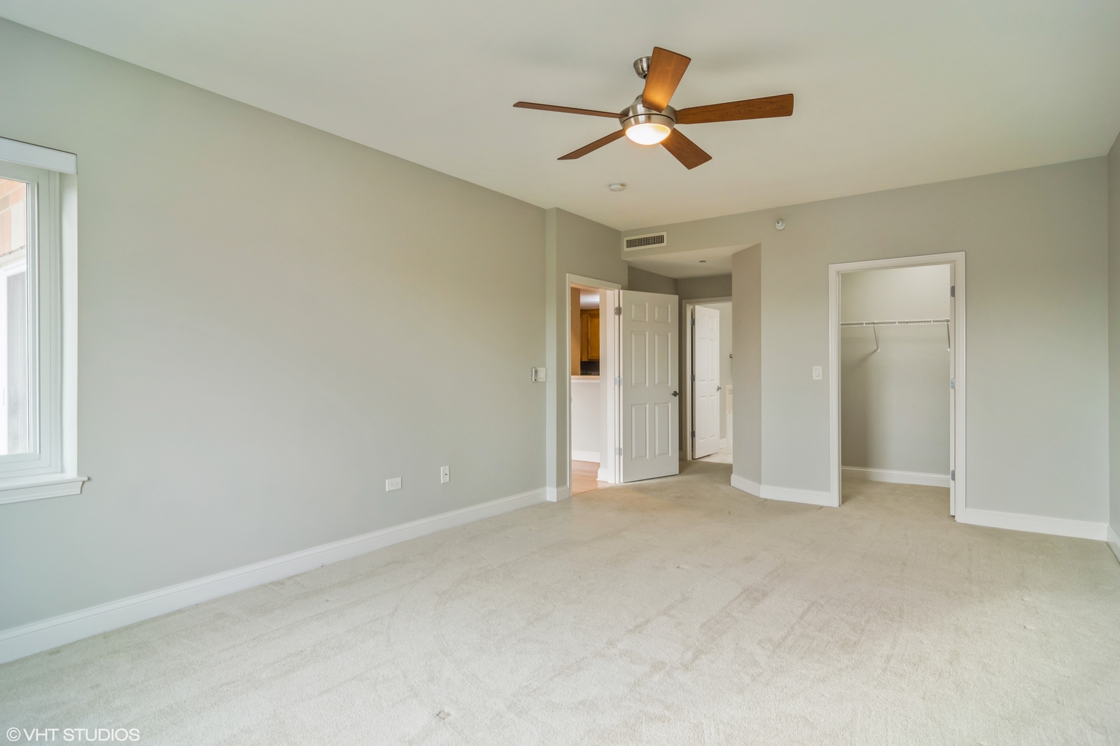 125 North Buffalo Grove Road, Unit 110 Buffalo Grove, IL 60089 - Photo 8 of 14 an empty room with ceiling fan and window