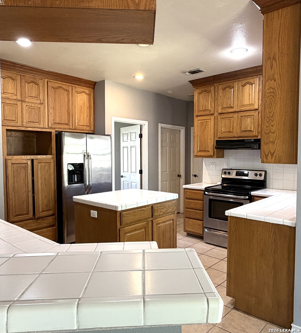 10565 Briggs Road Atascosa, TX 78002 - Photo 15 of 59 a kitchen with stainless steel appliances granite countertop a stove top oven a refrigerator a sink and dishwasher