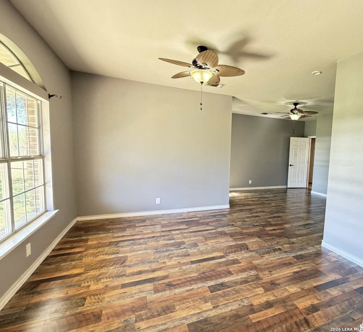 10565 Briggs Road Atascosa, TX 78002 - Photo 4 of 59 an empty room with wooden floor fan and windows