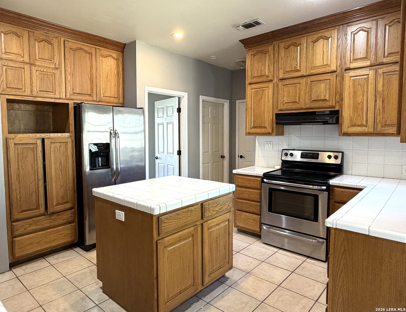 10565 Briggs Road Atascosa, TX 78002 - Photo 10 of 59 a kitchen with stainless steel appliances granite countertop a stove and a refrigerator