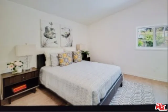 a bedroom with a bed and painting on the wall