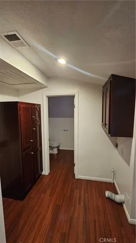 a view of a hallway with wooden floor and closet