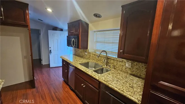 a bathroom with a granite countertop sink and a large mirror