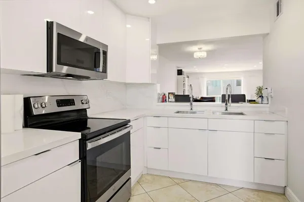 a kitchen with white cabinets stainless steel appliances and sink