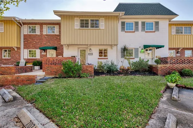 a front view of a house with a garden and plants