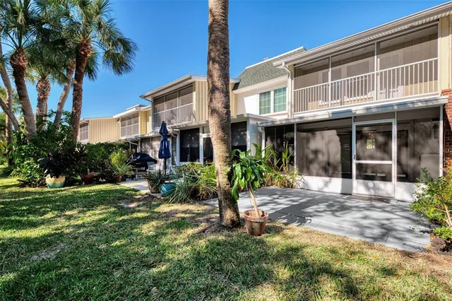 an aerial view of ocean and residential houses with outdoor space