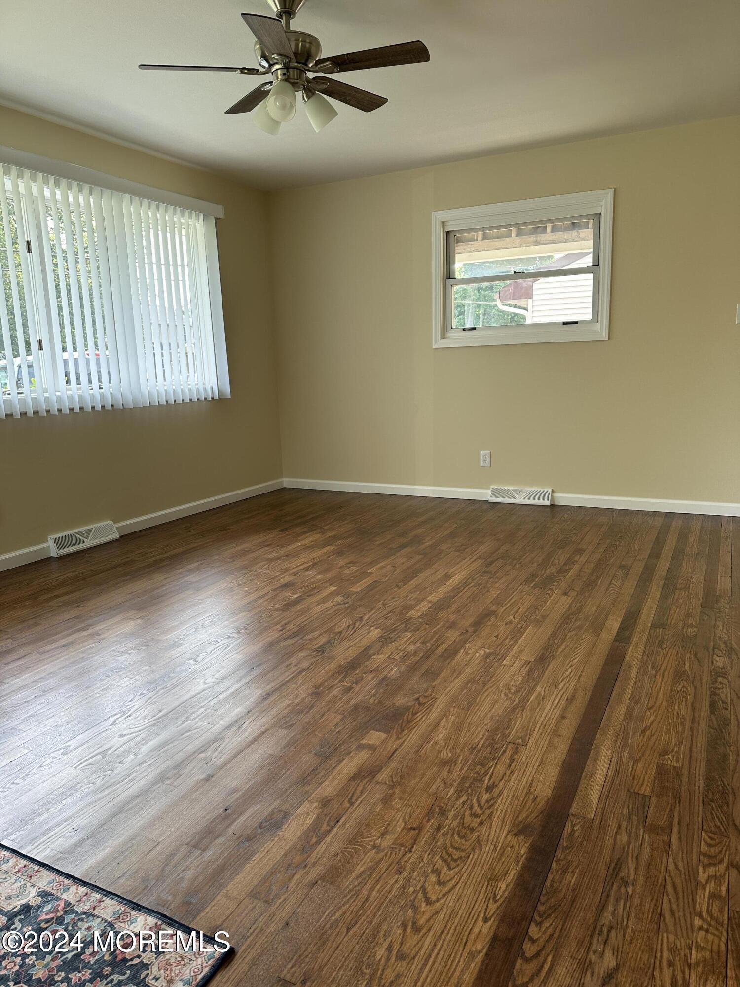 21 Middlesex Road Matawan, NJ 07747 - Photo 6 of 19 an empty room with wooden floor windows and fan