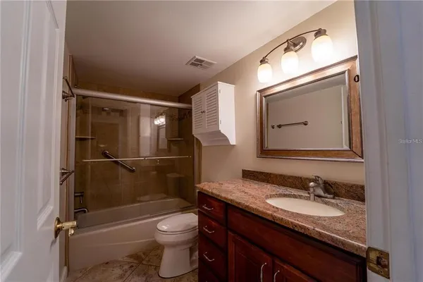 a bathroom with a granite countertop sink toilet and shower
