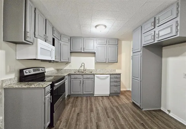 a kitchen with granite countertop wooden cabinets stainless steel appliances and a window
