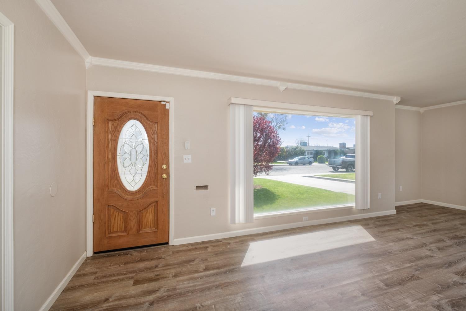 1223 Cyrier Avenue Reedley, CA 93654 - Photo 3 of 21 an empty room with wooden floor and window