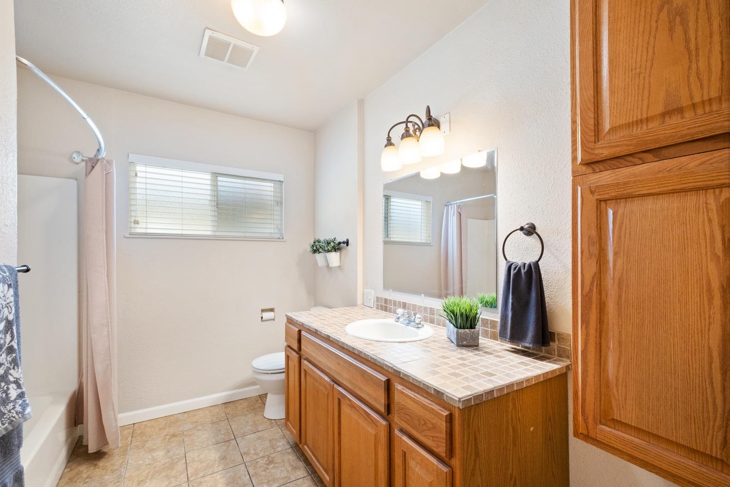 1223 Cyrier Avenue Reedley, CA 93654 - Photo 10 of 21 a bathroom with a granite countertop sink and a mirror