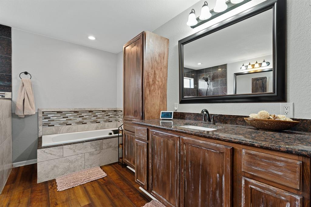 5058 West Highway 199 Springtown, TX 76082 - Photo 26 of 40 a bathroom with a granite countertop sink a mirror and a toilet