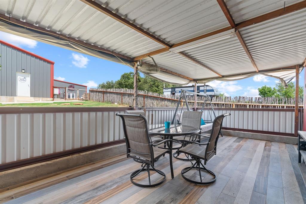 5058 West Highway 199 Springtown, TX 76082 - Photo 38 of 40 a view of a roof deck with table and chairs and wooden floor