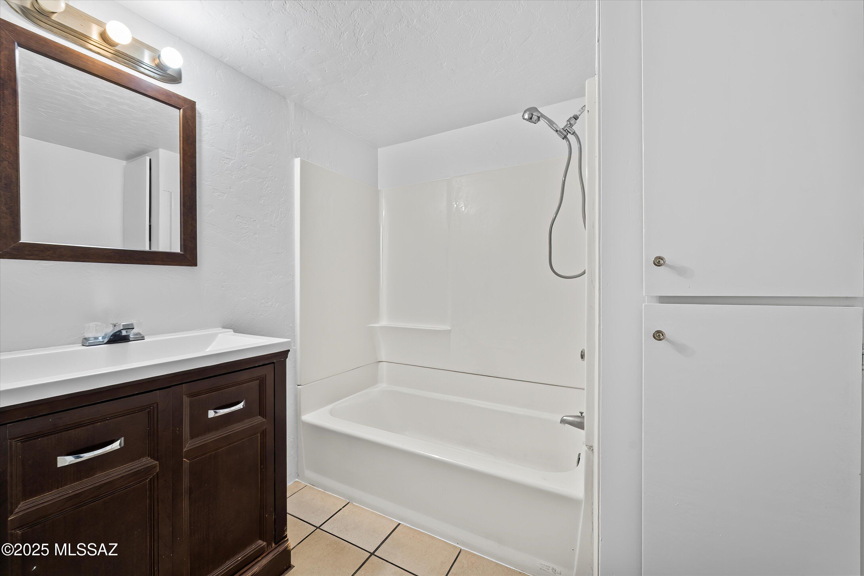 1227 East Ginter Road Tucson, AZ 85706 - Photo 15 of 18 a bathroom with a bath tub sink vanity and mirror
