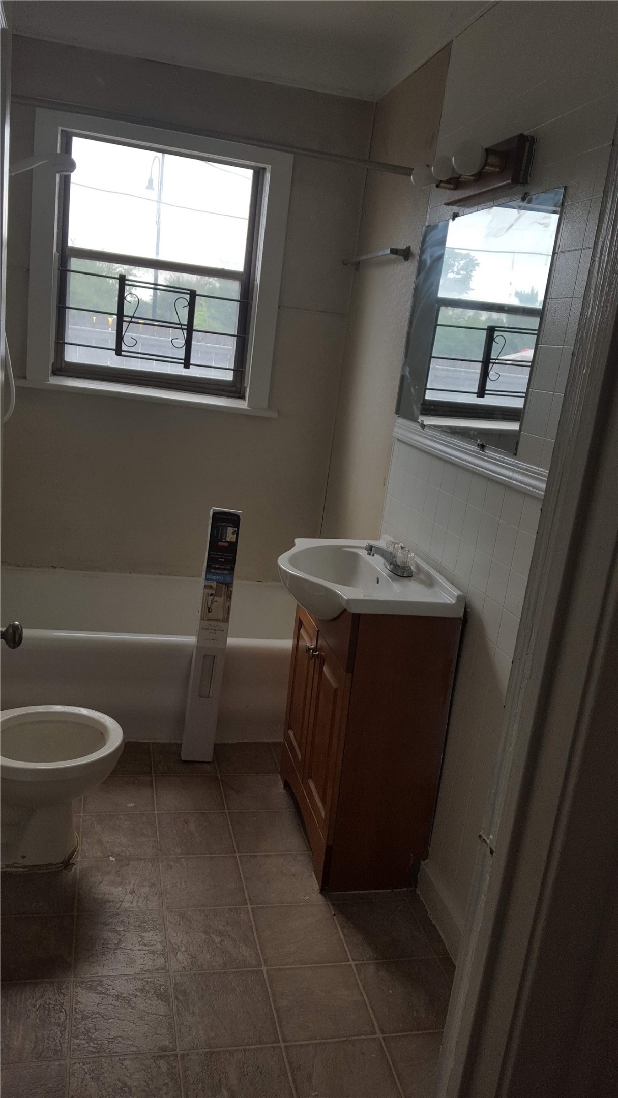 1828 Rosedale Street Houston, TX 77004 - Photo 29 of 32 a bathroom with a toilet sink and mirror