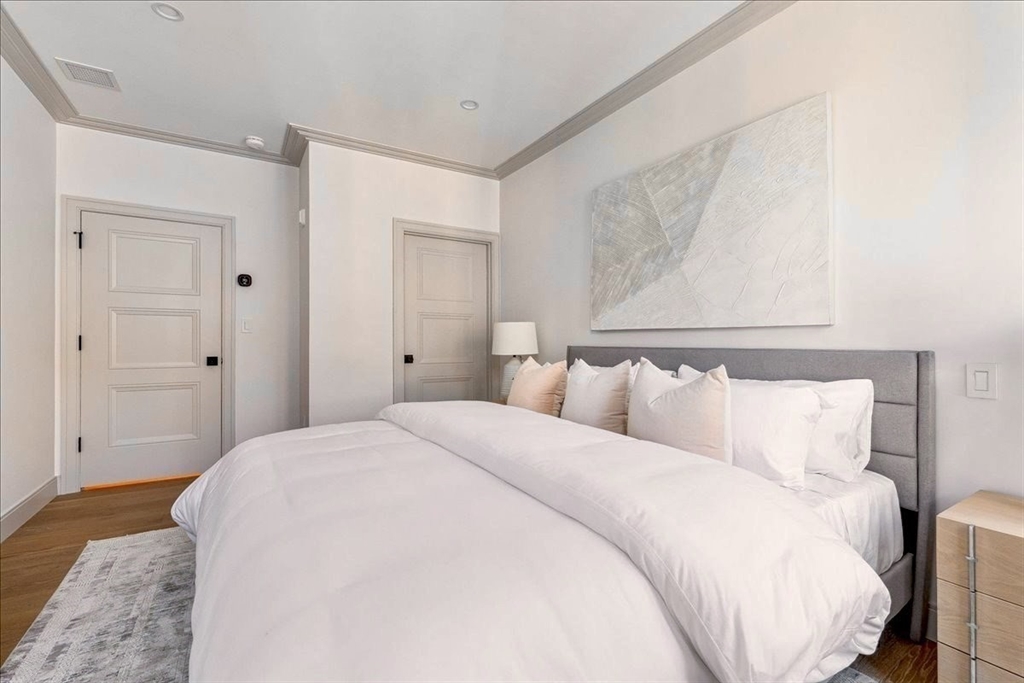 57 University Road, Unit 3 Brookline, MA 02445 - Photo 7 of 20 a bedroom with a bed and a mirror