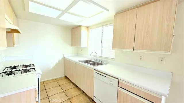 a kitchen with a sink cabinets and a window