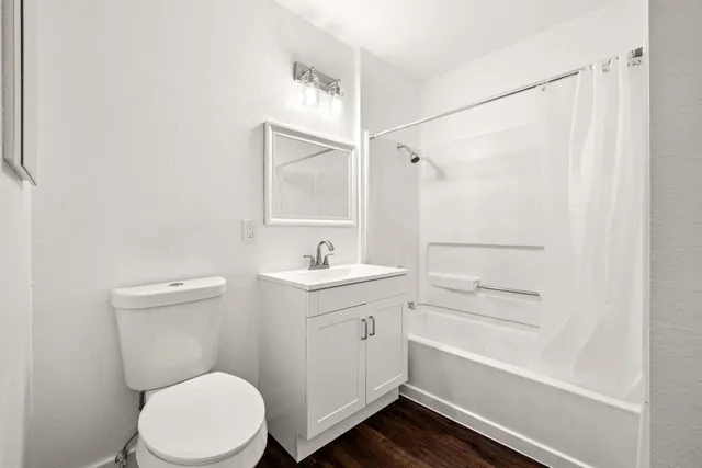 an empty room with wooden floor and white walls