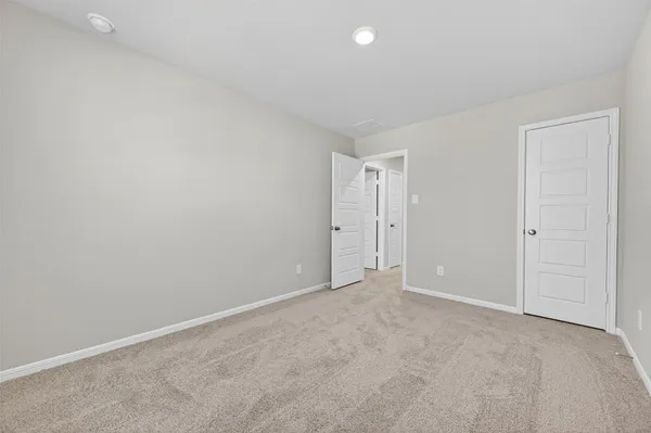 an empty room with ceiling fan and window