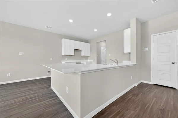 a kitchen with wooden floors and white cabinets