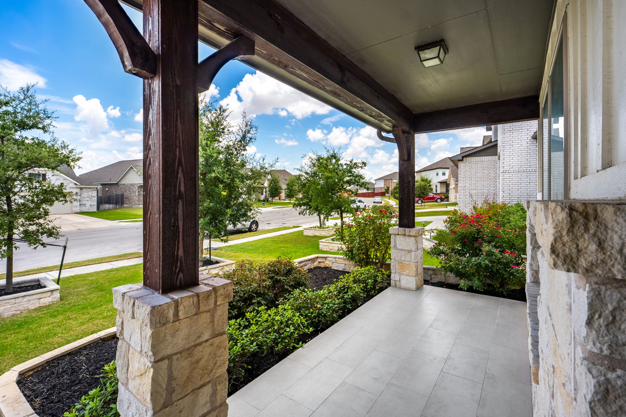20813 Carries Ranch Road Pflugerville, TX 78660 - Photo 3 of 40 Stately stone pillars and modern tile flooring define this inviting covered front porch entrance.