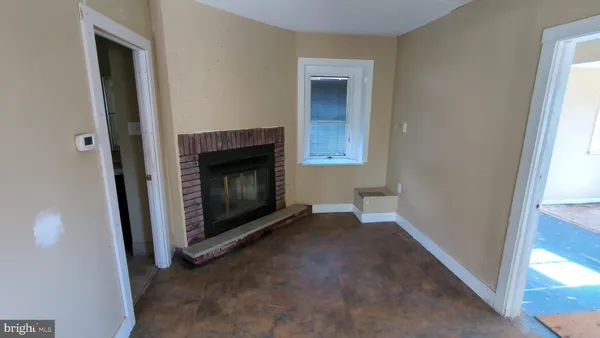 a view of an empty room with a fireplace and a window