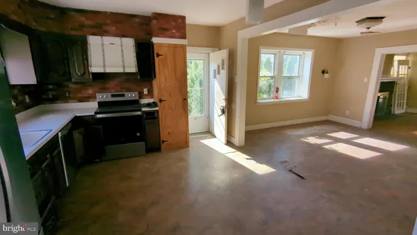 a kitchen with granite countertop a refrigerator stove and sink