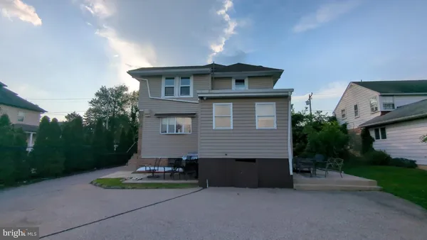 a view of a house with a yard and potted plants