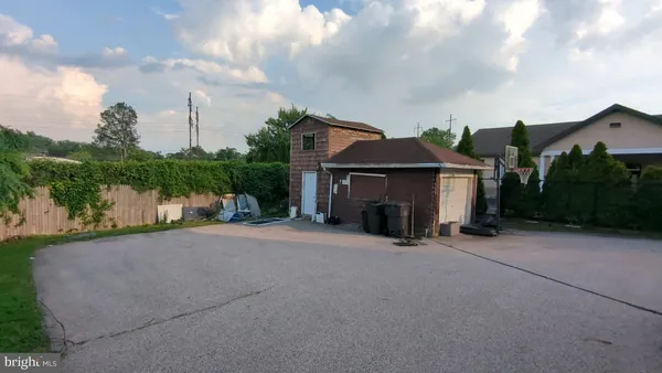 a view of a house with a small yard and a large tree