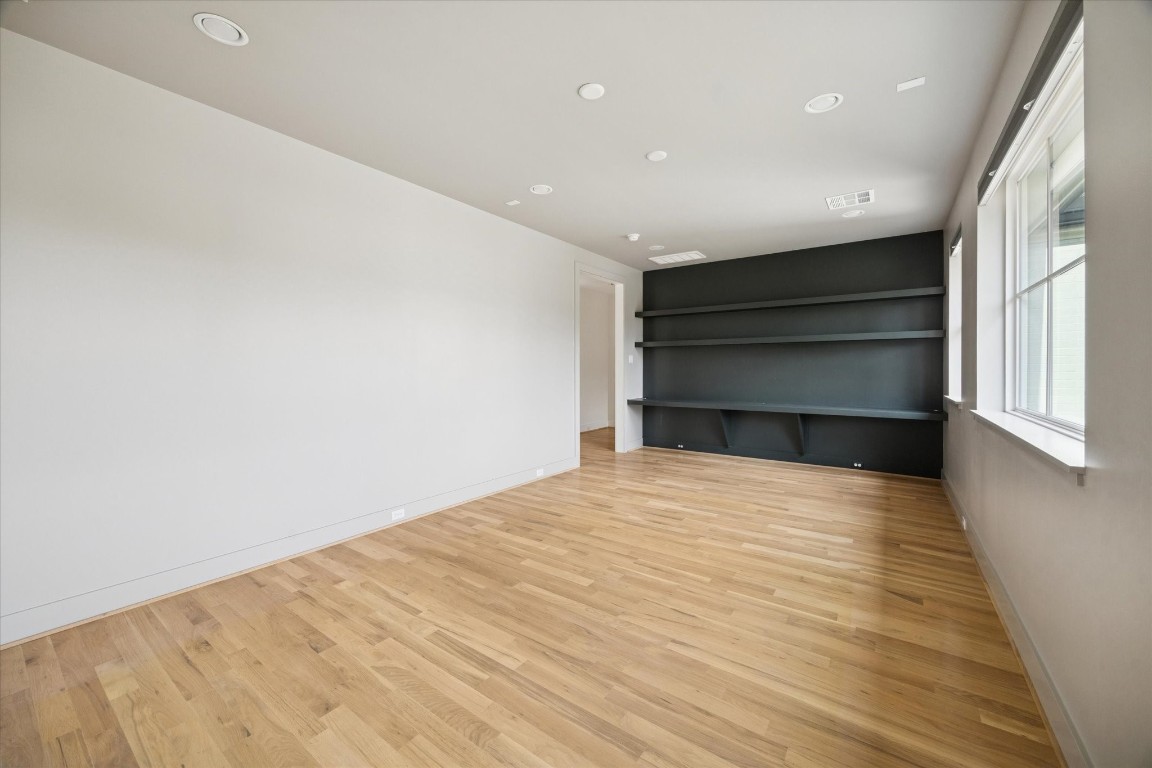 4219 Alba Road Houston, TX 77018 - Photo 20 of 39 Versatile room with hardwood flooring, recessed lighting, and custom built-in shelving—ideal for a bedroom, office, or media space.