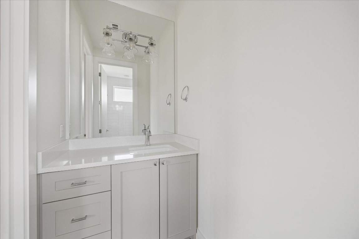 4219 Alba Road Houston, TX 77018 - Photo 31 of 39 Custom vanity with quartz countertop, ample storage, and oversized mirror with contemporary lighting.