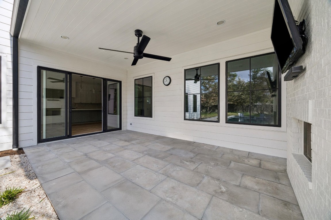 4219 Alba Road Houston, TX 77018 - Photo 35 of 39 Spacious covered outdoor living area with sliding glass doors, ceiling fan, outdoor fireplace, and seamless indoor-outdoor flow.