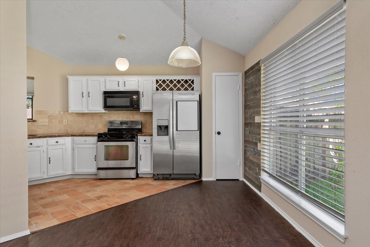 6022 Sean Court Humble, TX 77346 - Photo 5 of 18 a kitchen with granite countertop a refrigerator and a stove top oven