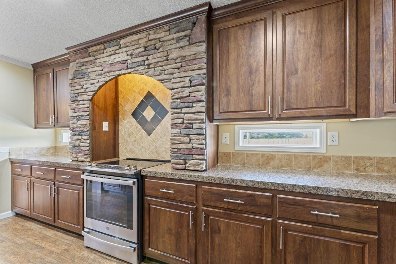 161 Mulchi Road Norlina, NC 27563 - Photo 16 of 38 a kitchen with granite countertop a sink and a stove