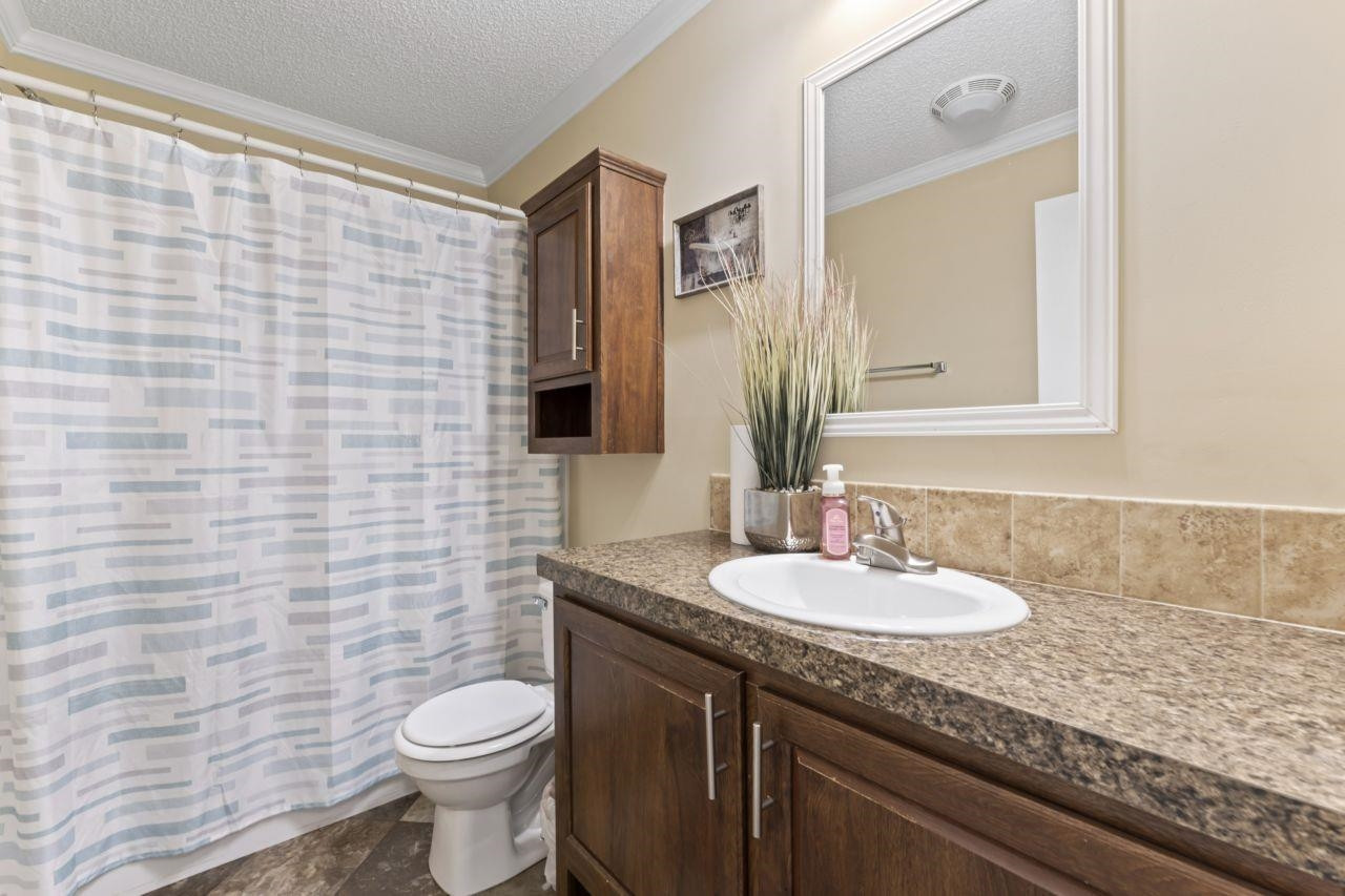 161 Mulchi Road Norlina, NC 27563 - Photo 26 of 38 a bathroom with a granite countertop toilet sink and mirror