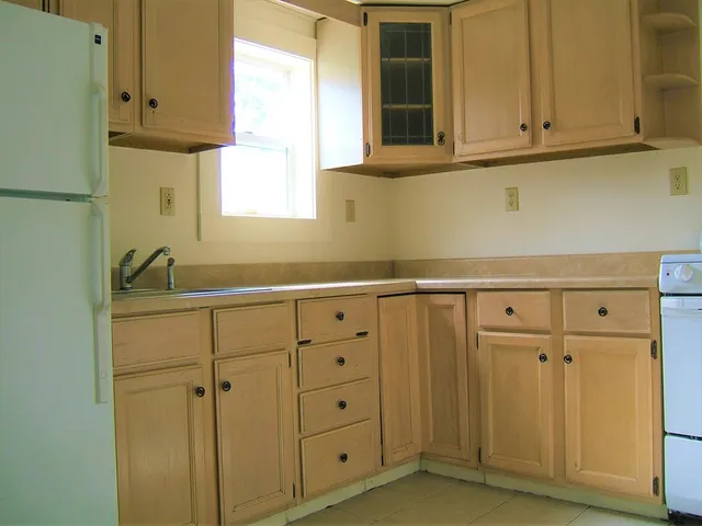 a kitchen with white cabinets and white appliances