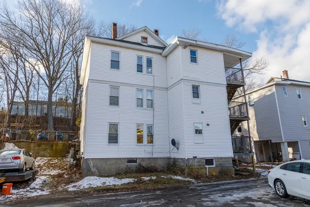 a view of a kitchen with white cabinets and a window