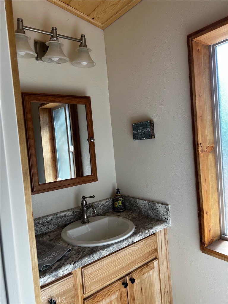 98443 Sierra Meadow Road Inyokern, CA 93527 - Photo 12 of 62 a bathroom with a granite countertop sink and a mirror
