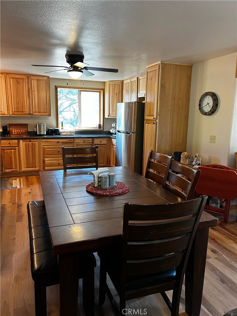 98443 Sierra Meadow Road Inyokern, CA 93527 - Photo 18 of 62 a room with a table chairs and a refrigerator