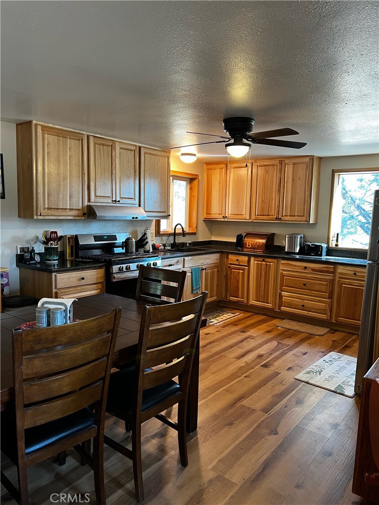 98443 Sierra Meadow Road Inyokern, CA 93527 - Photo 19 of 62 a kitchen with stainless steel appliances granite countertop wooden cabinets a stove top oven a sink and dishwasher