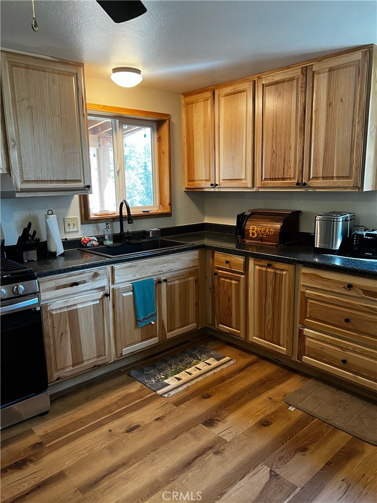 98443 Sierra Meadow Road Inyokern, CA 93527 - Photo 7 of 62 a kitchen with granite countertop a sink cabinets and wooden floor