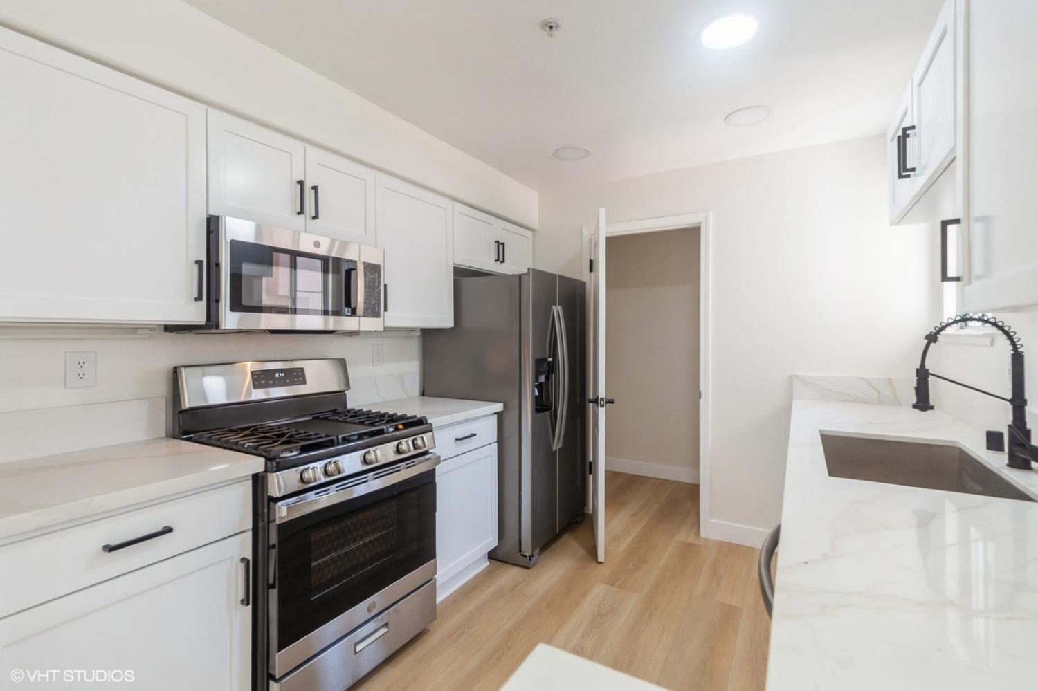 987 Asilomar Terrace, Unit 2 Sunnyvale, CA 94086 - Photo 20 of 48 a kitchen with stainless steel appliances a refrigerator stove and microwave