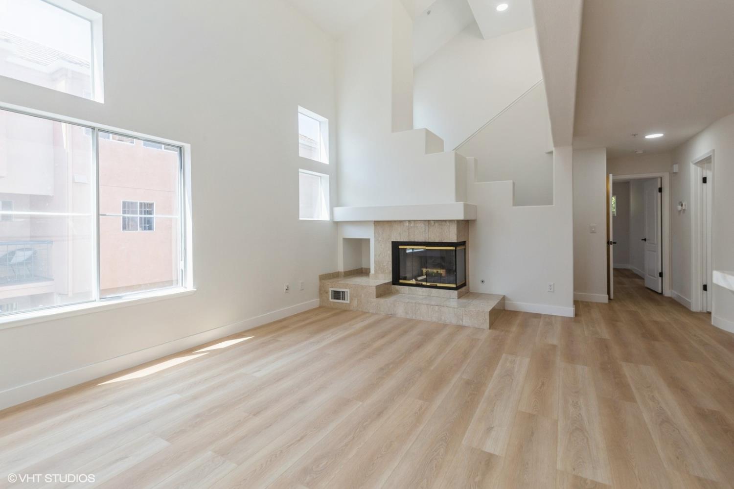 987 Asilomar Terrace, Unit 2 Sunnyvale, CA 94086 - Photo 22 of 48 a view of empty room with wooden floor and fireplace
