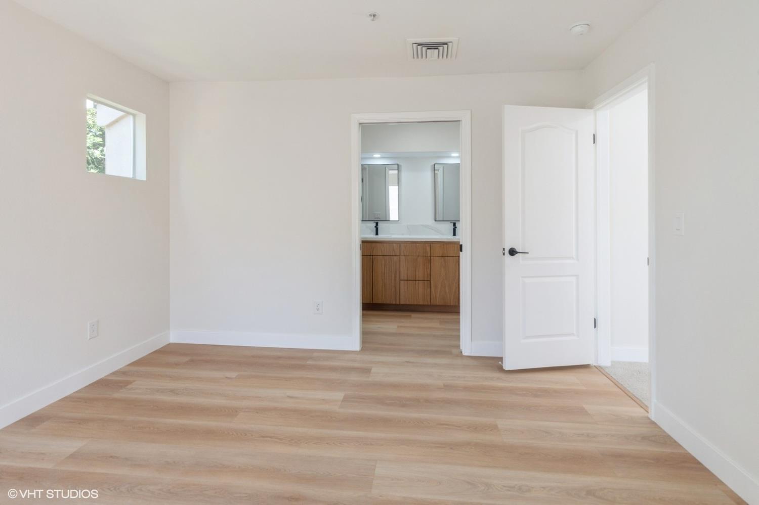 987 Asilomar Terrace, Unit 2 Sunnyvale, CA 94086 - Photo 36 of 48 an empty room with wooden floor and bathroom